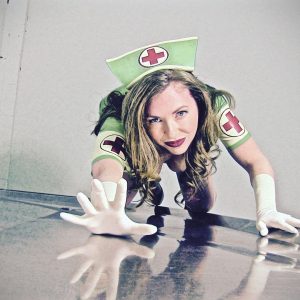 Mistress T in a green nurses outfit