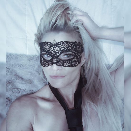 Lilith Veiled wearing a black mask and tie